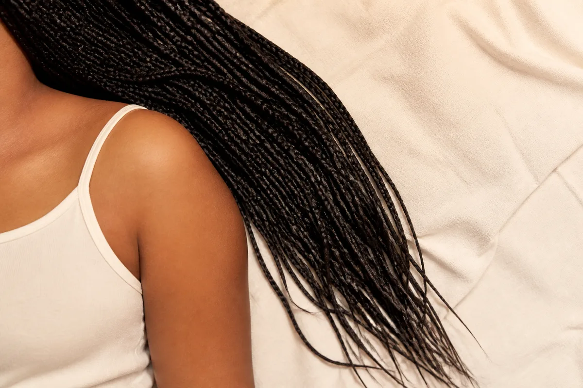 Vue rapprochée de longues box braids retombant sur une épaule, texture des tresses bien visible
