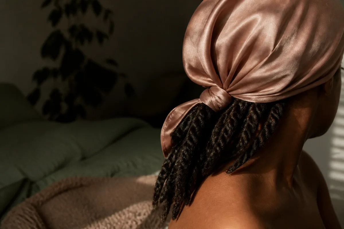 Torsades lâches rassemblées avant la nuit sous un foulard en satin