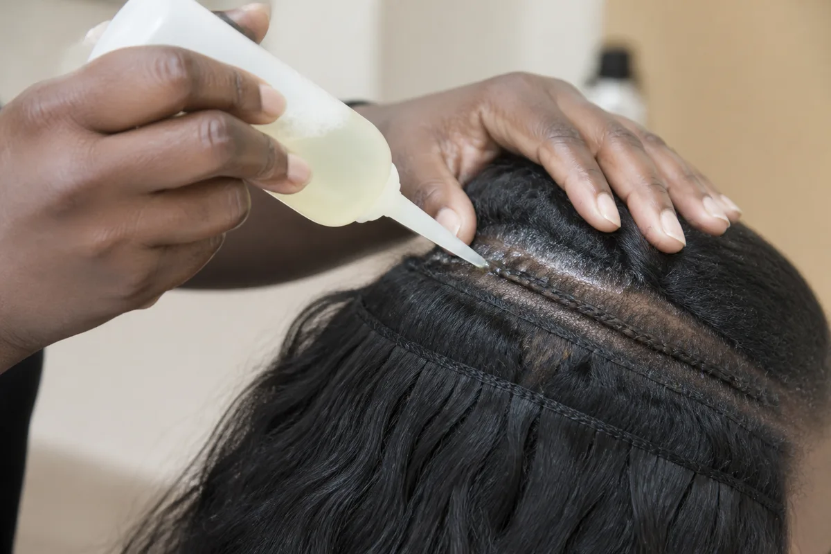 Application d’un shampoing dilué le long des raies d’un tissage cousu